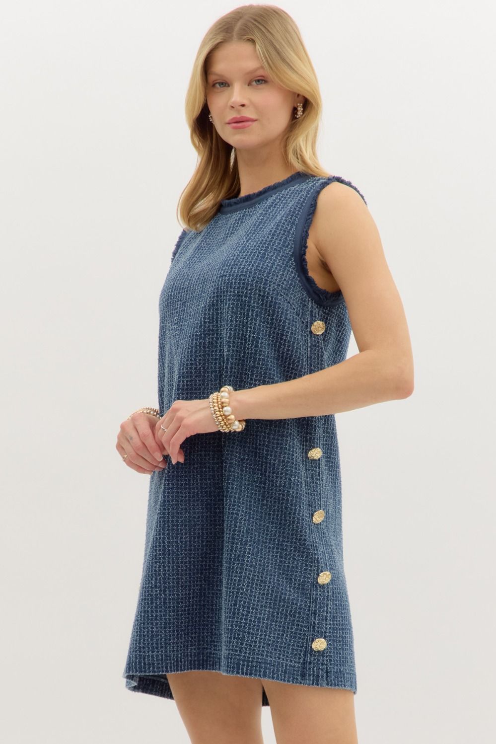 Denim distressed sleeveless mini dress featuring gold accent buttons along side. Small Denim distressed sleeveless mini dress featuring gold accent buttons along side. Small
