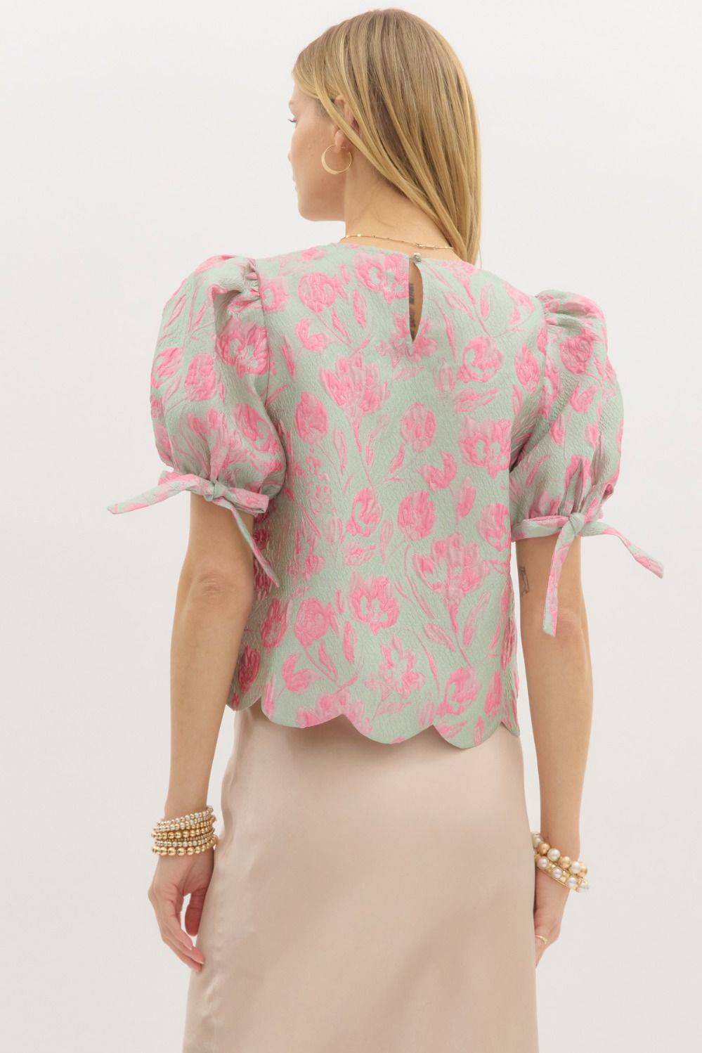 Floral jacquard pullover top featuring scallop hem.