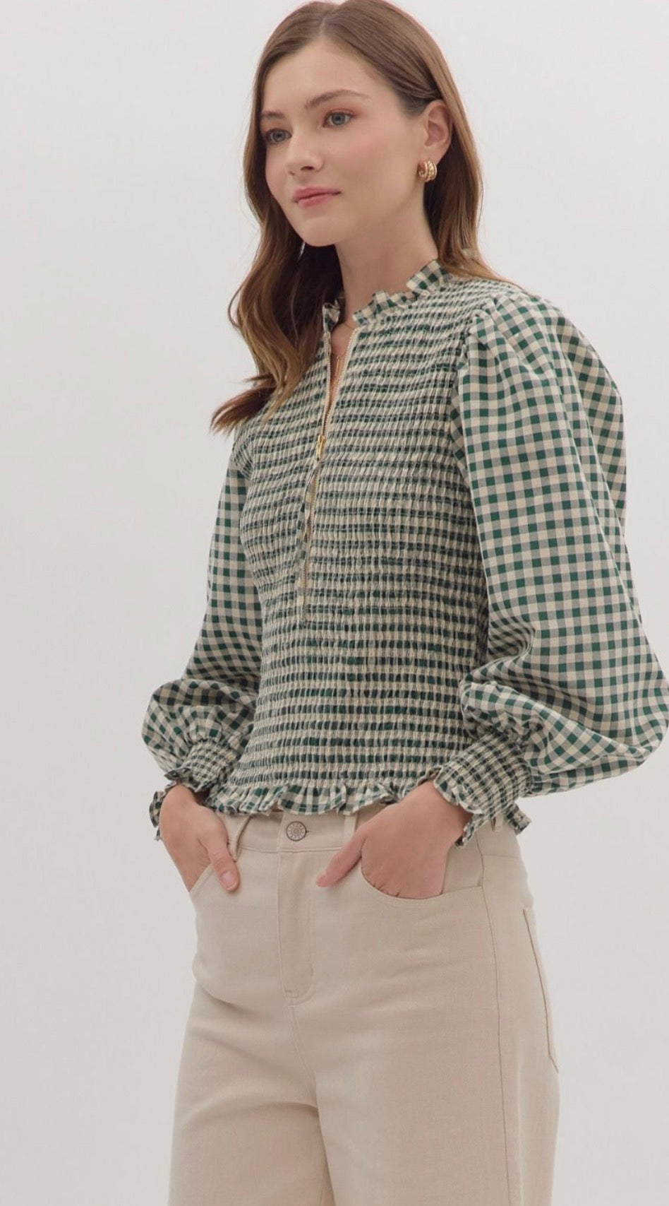 Gingham long puff sleeve top featuring smocked bodice and ruffle hem. Zip closure at front