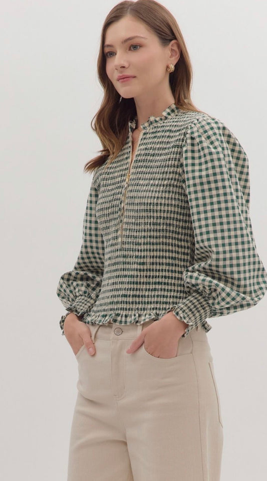 Gingham long puff sleeve top featuring smocked bodice and ruffle hem. Zip closure at front