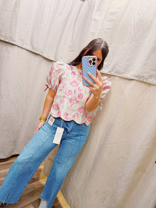 Floral jacquard pullover top featuring scallop hem.